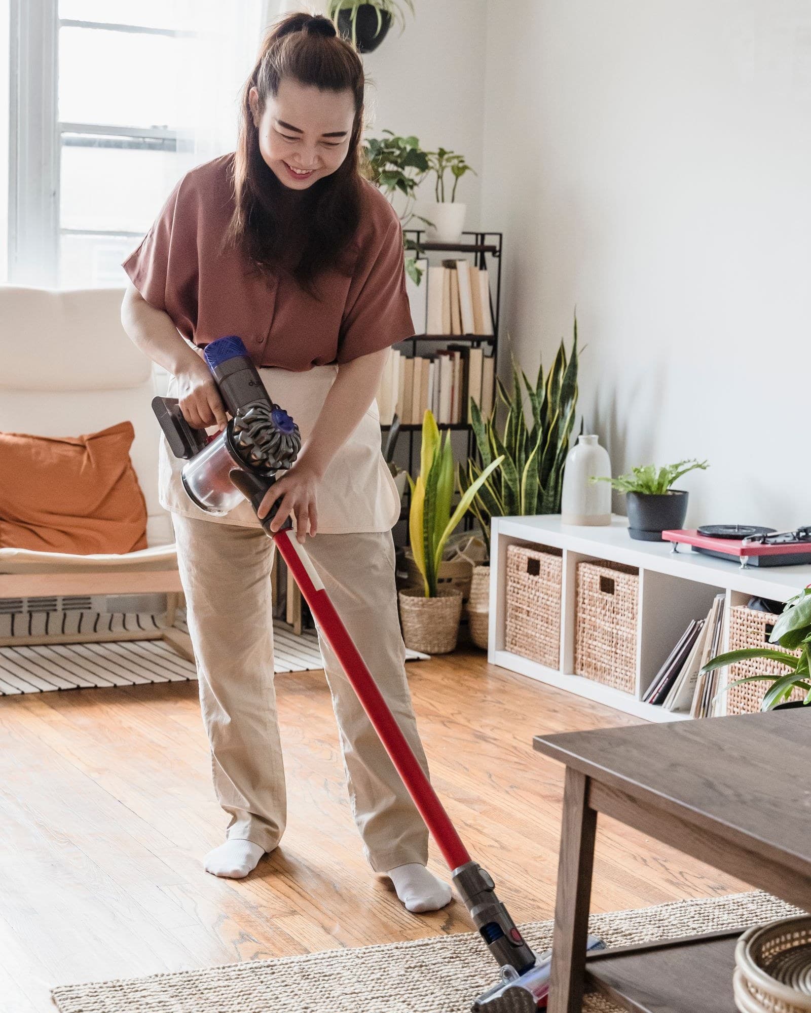 A helper hoovering a bright living room