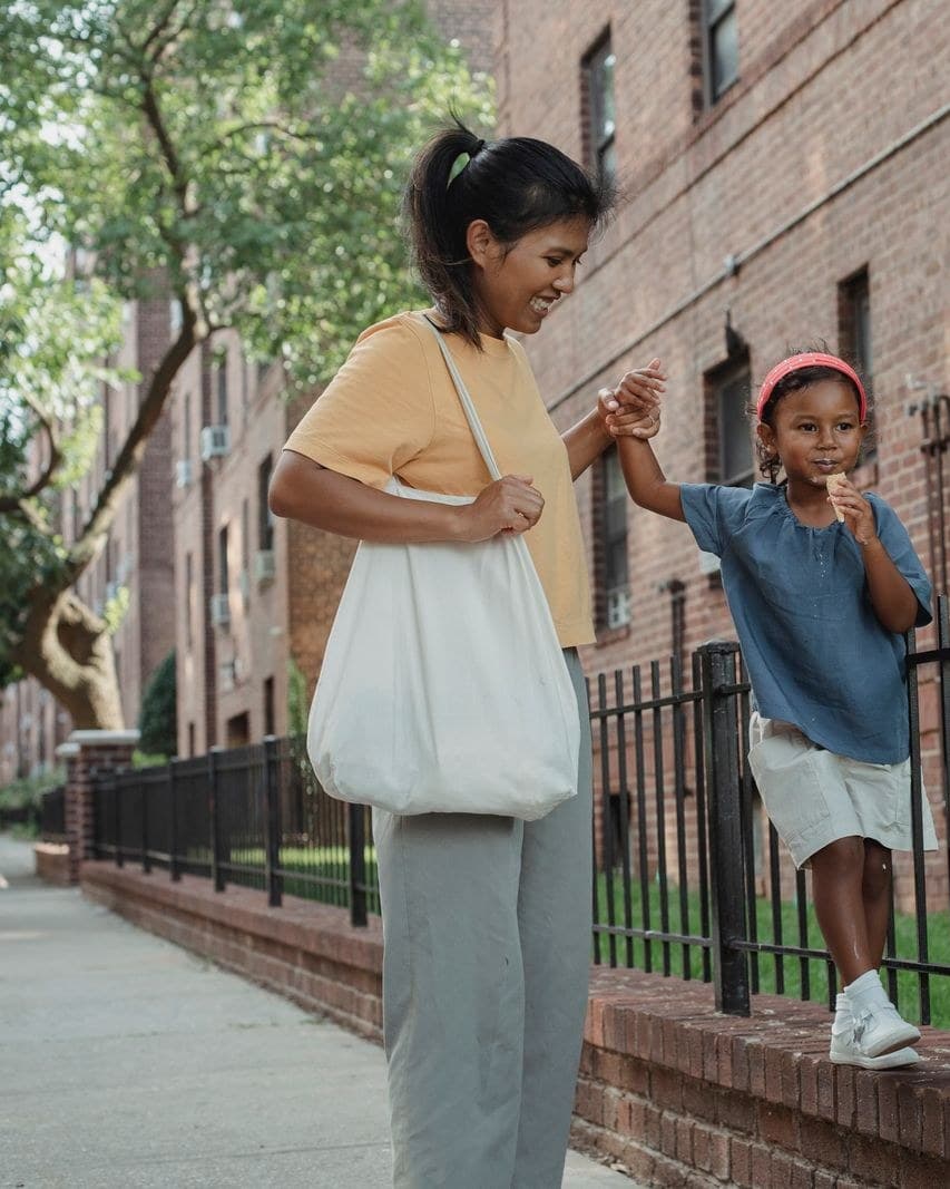A young helper walking home from school hand in hand with a child